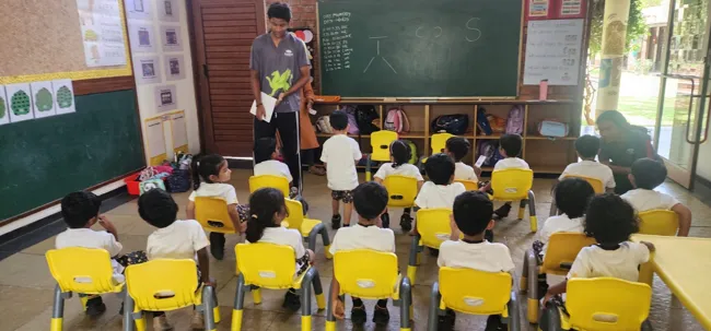 A volunteer leading a classroom session with primary students